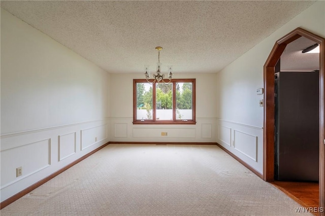 64 Bywater Dr, Amherst, NY 14068 - unfurnished room with a chandelier, light colored carpet, a wainscoted wall, a textured ceiling, and a decorative wall
