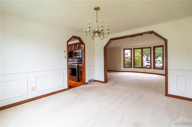 64 Bywater Dr, Amherst, NY 14068 - unfurnished dining area with arched walkways, light carpet, a chandelier, a decorative wall, and a wainscoted wall