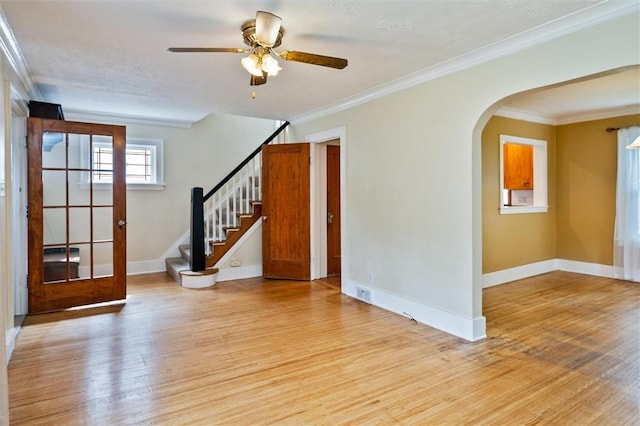 199 Brett Rd, Irondequoit, NY 14609 - unfurnished room featuring light wood-type flooring, crown molding, arched walkways, a ceiling fan, and stairway