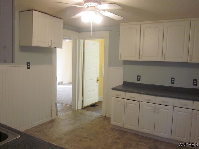 129 Albert Ave, Buffalo, NY 14207 - kitchen featuring a wainscoted wall, dark countertops, ceiling fan, and white cabinets