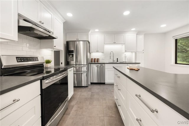 4797 Huntwood, Manlius, NY 13104 - kitchen featuring appliances with stainless steel finishes, under cabinet range hood, dark countertops, tasteful backsplash, and white cabinets
