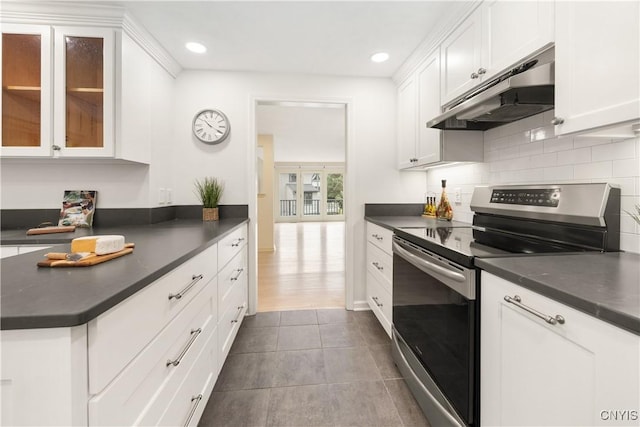 4797 Huntwood, Manlius, NY 13104 - kitchen with electric range, under cabinet range hood, dark countertops, white cabinets, and decorative backsplash