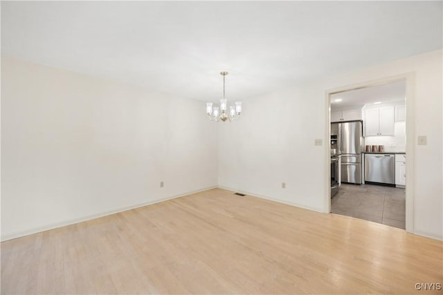 4797 Huntwood, Manlius, NY 13104 - empty room with light wood-type flooring and a chandelier