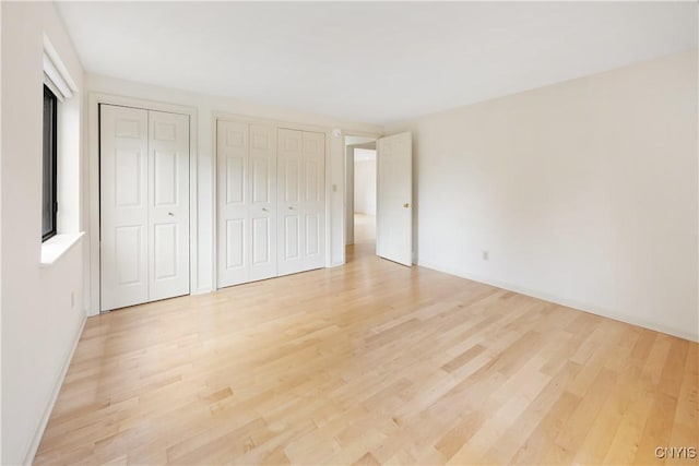 4797 Huntwood, Manlius, NY 13104 - unfurnished bedroom featuring multiple closets and light wood-style floors