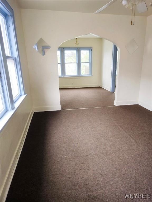 1310 E Lovejoy St, Buffalo, NY 14206 - unfurnished room with arched walkways, a ceiling fan, and carpet floors