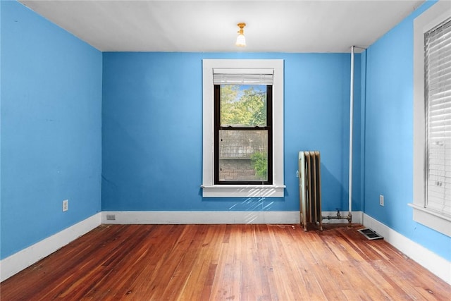 9 Orchard St, Delhi, NY 13753 - empty room with wood-type flooring and radiator heating unit