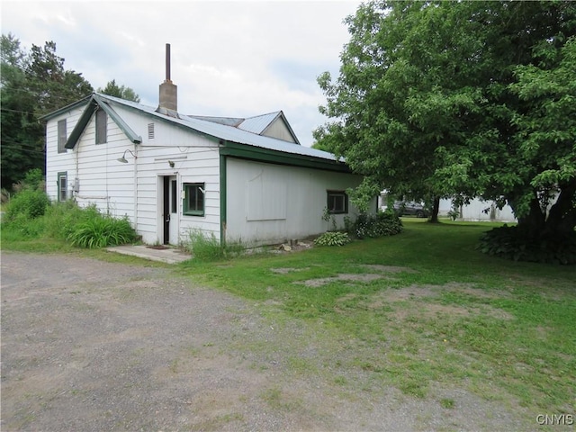 7285 State Route 812, Lowville, NY 13367 - view of side of property with a chimney, a yard, and a metal roof