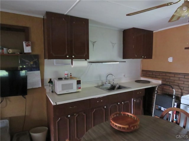 7285 State Route 812, Lowville, NY 13367 - kitchen with white microwave, crown molding, a ceiling fan, light countertops, and dark brown cabinets