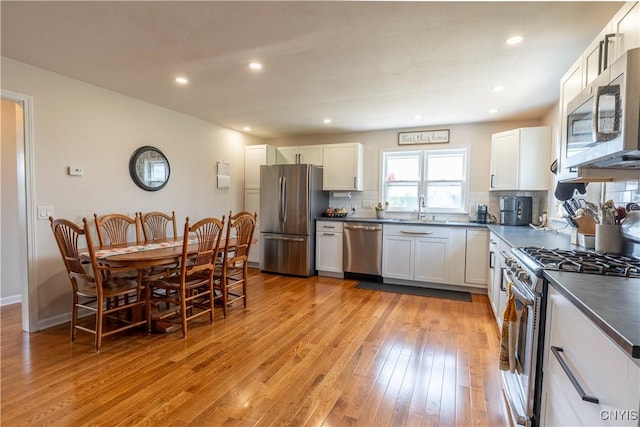 4045 E Milestrip Rd, Fenner, NY 13032 - kitchen featuring stainless steel appliances, light wood-type flooring, tasteful backsplash, dark countertops, and white cabinets