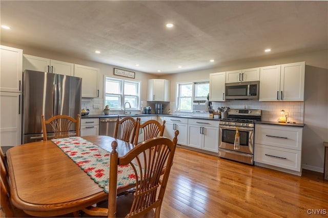 4045 E Milestrip Rd, Fenner, NY 13032 - kitchen featuring appliances with stainless steel finishes, dark countertops, light wood-style floors, white cabinetry, and backsplash