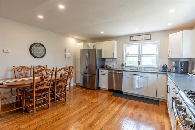 4045 E Milestrip Rd, Fenner, NY 13032 - kitchen with appliances with stainless steel finishes, light wood-style floors, tasteful backsplash, dark countertops, and recessed lighting