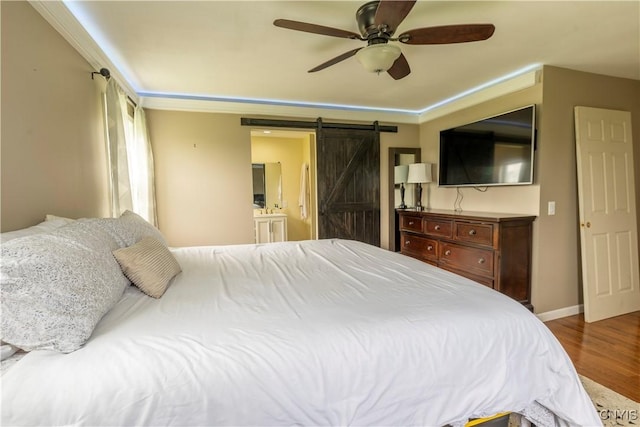 4045 E Milestrip Rd, Fenner, NY 13032 - bedroom featuring a barn door, wood finished floors, a ceiling fan, and connected bathroom
