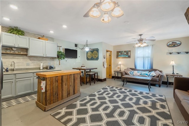 2012 Pleasant Ave, Vienna, NY 13308 - kitchen featuring butcher block counters, tasteful backsplash, open floor plan, a chandelier, and ceiling fan