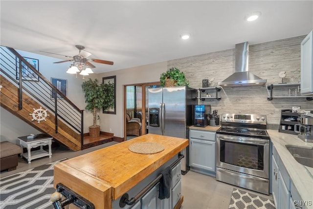 2012 Pleasant Ave, Vienna, NY 13308 - kitchen featuring wall chimney exhaust hood, appliances with stainless steel finishes, butcher block countertops, a ceiling fan, and gray cabinetry