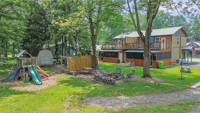 2012 Pleasant Ave, Vienna, NY 13308 - view of grassy yard featuring a fire pit, a storage shed, a playground, and view of scattered trees