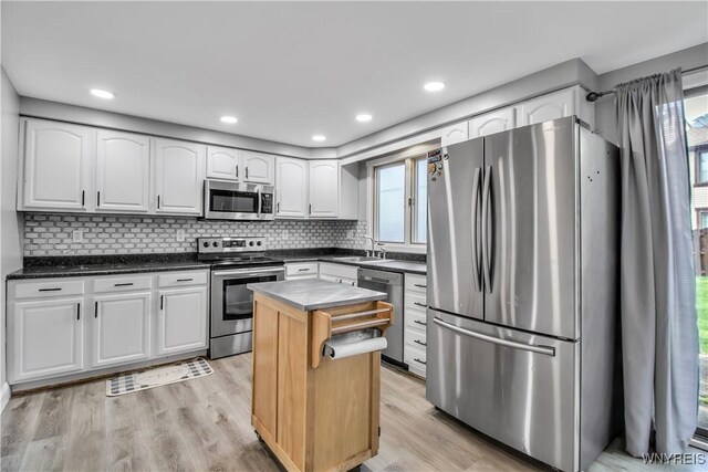 351 Charlesgate Cir, Amherst, NY 14051 - kitchen featuring appliances with stainless steel finishes, white cabinets, light wood finished floors, tasteful backsplash, and a center island
