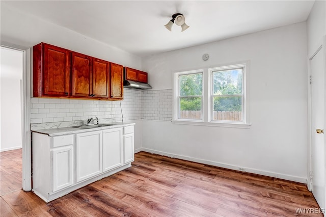 66 Schmarbeck Ave, Buffalo, NY 14212 - kitchen featuring light countertops, light wood-style floors, tasteful backsplash, under cabinet range hood, and white cabinetry