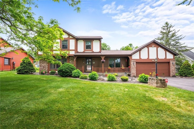 99 Old English Dr, Greece, NY 14616 - tudor-style house featuring a porch, a front yard, a garage, driveway, and brick siding
