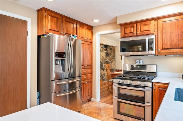 99 Old English Dr, Greece, NY 14616 - kitchen with appliances with stainless steel finishes, light countertops, recessed lighting, and brown cabinets
