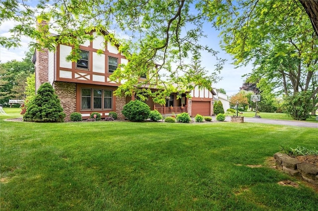 99 Old English Dr, Greece, NY 14616 - english style home with a front yard, a chimney, driveway, a garage, and stucco siding