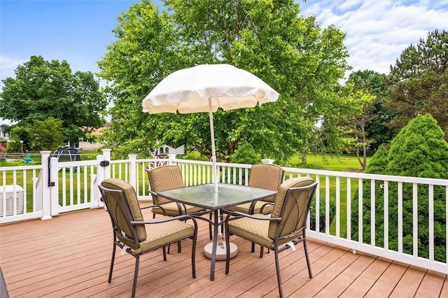 99 Old English Dr, Greece, NY 14616 - wooden terrace with outdoor dining space, a lawn, and view of wooded area