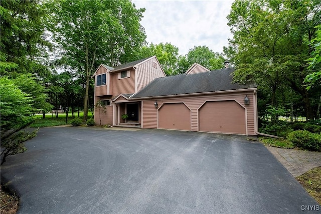4582 Whetstone Rd, Manlius, NY 13104 - view of front of house featuring a garage, driveway, and view of wooded area