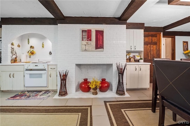 4582 Whetstone Rd, Manlius, NY 13104 - kitchen with white electric range oven, beamed ceiling, light tile patterned floors, white cabinetry, and light countertops