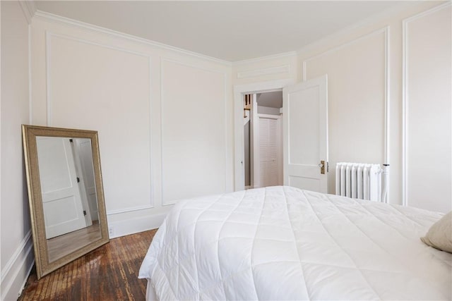 905 W Center St, Ridgeway, NY 14103 - bedroom with radiator, a decorative wall, dark wood-style floors, and crown molding