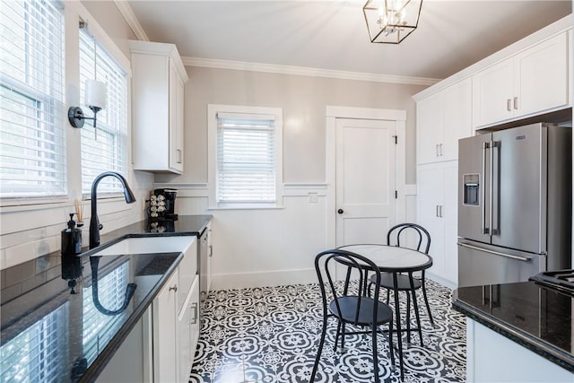 905 W Center St, Ridgeway, NY 14103 - kitchen with high quality fridge, plenty of natural light, white cabinets, dark stone counters, and a wainscoted wall