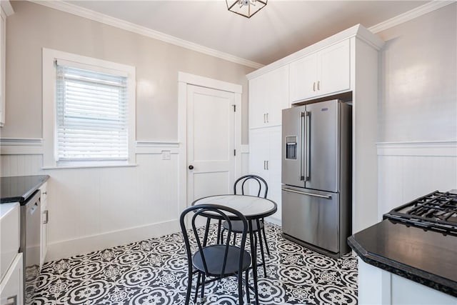 905 W Center St, Ridgeway, NY 14103 - kitchen featuring appliances with stainless steel finishes, a wainscoted wall, dark countertops, crown molding, and white cabinets