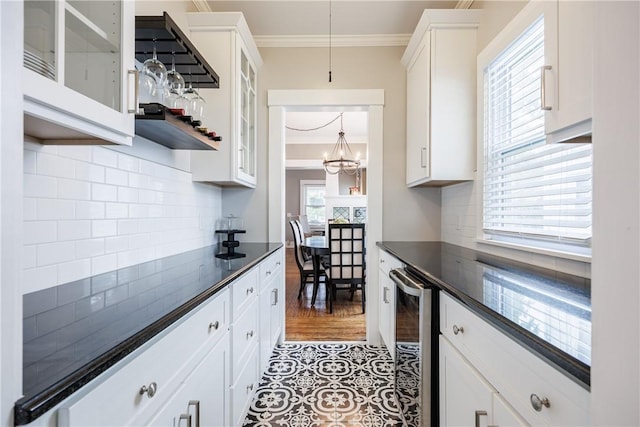 905 W Center St, Ridgeway, NY 14103 - kitchen with dark countertops, beverage cooler, crown molding, a chandelier, and white cabinetry