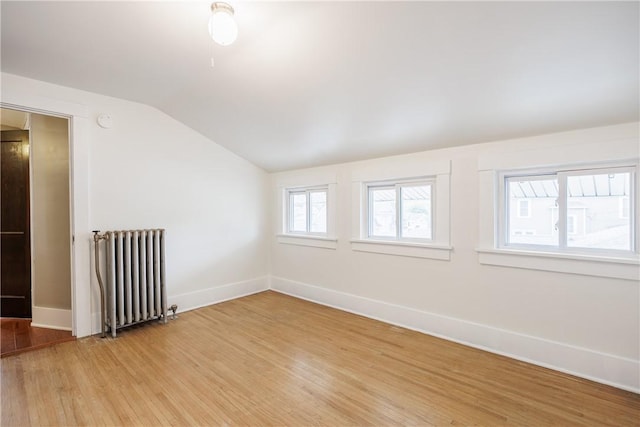905 W Center St, Ridgeway, NY 14103 - empty room featuring radiator heating unit, lofted ceiling, and light wood-style floors