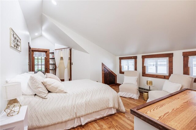 905 W Center St, Ridgeway, NY 14103 - bedroom featuring lofted ceiling, light wood finished floors, a baseboard heating unit, and multiple windows
