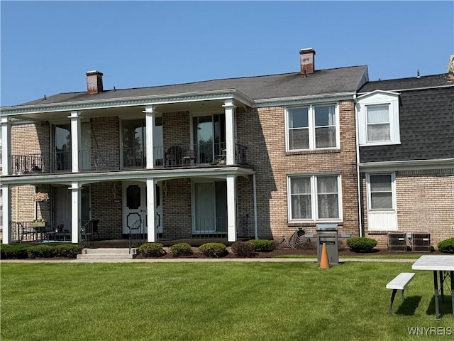 73 Henel Ave Unit 5, Amherst, NY 14226 - view of front of house featuring a balcony, brick siding, covered porch, a front yard, and a chimney