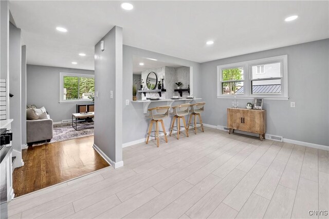 8478 Grandview Dr, Cicero, NY 13039 - kitchen with a kitchen breakfast bar, wood finished floors, and recessed lighting
