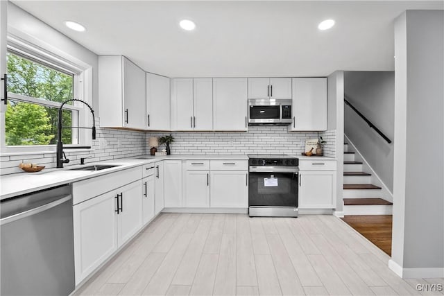8478 Grandview Dr, Cicero, NY 13039 - kitchen with stainless steel appliances, light countertops, backsplash, white cabinets, and recessed lighting
