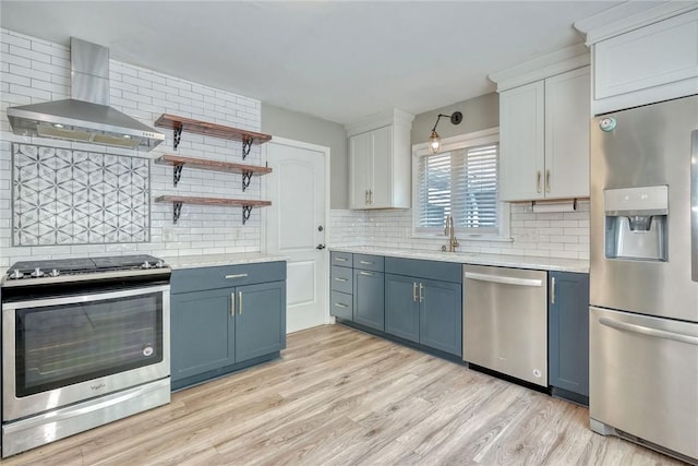 244 Highland Pkwy, Rochester, NY 14620 - kitchen featuring stainless steel appliances, wall chimney exhaust hood, decorative backsplash, and blue cabinetry