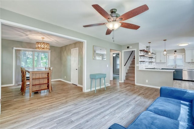 244 Highland Pkwy, Rochester, NY 14620 - living area featuring light wood-style flooring, stairway, a ceiling fan, and a chandelier