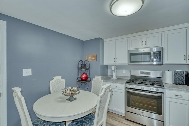 244 Highland Pkwy, Rochester, NY 14620 - kitchen with stainless steel appliances, white cabinets, light countertops, and light wood-style floors