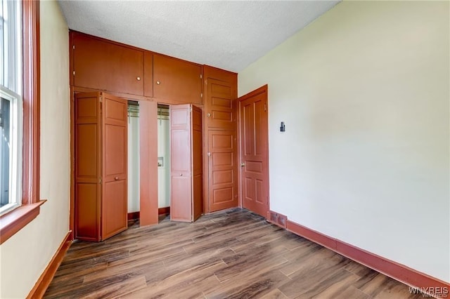 373 Urban St, Buffalo, NY 14211 - unfurnished bedroom featuring wood finished floors, a closet, and a textured ceiling