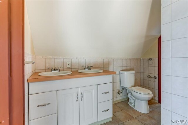 373 Urban St, Buffalo, NY 14211 - bathroom featuring tile walls, lofted ceiling, tile patterned flooring, and double vanity