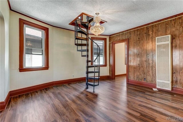 373 Urban St, Buffalo, NY 14211 - spare room featuring a heating unit, crown molding, a chandelier, wood finished floors, and stairway