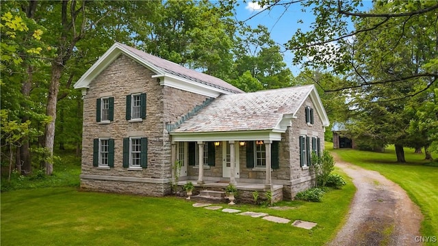 9999 Pierce Rd N, Trenton, NY 13354 - traditional home with a porch, a front lawn, stone siding, and asphalt driveway