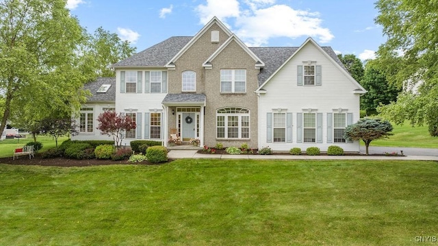 133 Raspberry Ln, Camillus, NY 13031 - colonial home with a front yard, roof with shingles, and brick siding