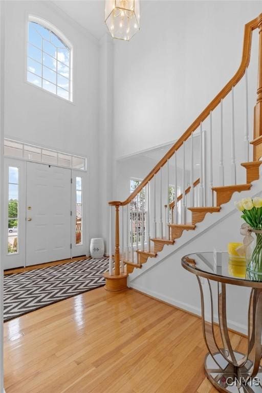 133 Raspberry Ln, Camillus, NY 13031 - entrance foyer featuring wood finished floors, a high ceiling, stairway, and a chandelier