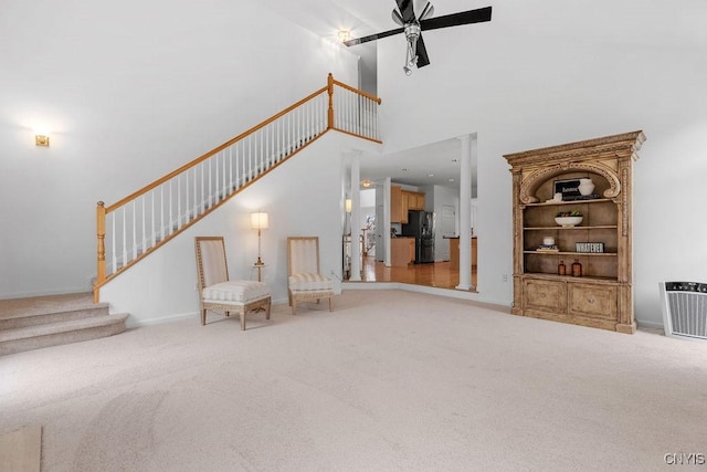 133 Raspberry Ln, Camillus, NY 13031 - living room featuring stairway, carpet floors, ceiling fan, a high ceiling, and ornate columns
