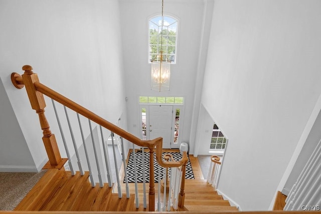 133 Raspberry Ln, Camillus, NY 13031 - staircase with a chandelier, plenty of natural light, a towering ceiling, and wood finished floors
