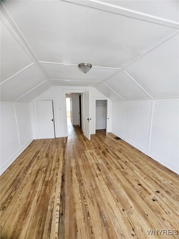 269 Westminster Ave, Buffalo, NY 14215 - additional living space featuring hardwood / wood-style flooring, vaulted ceiling, and a decorative wall