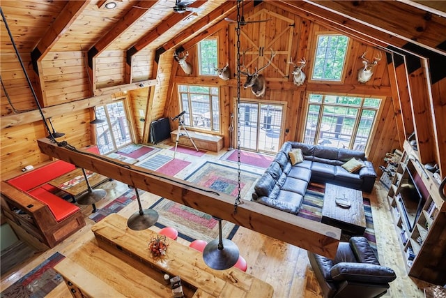 6684 Bishop Rd, Conesus, NY 14435 - living area with wood walls, healthy amount of natural light, vaulted ceiling, wood-type flooring, and ceiling fan
