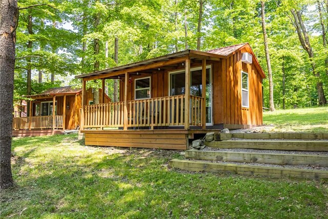 6684 Bishop Rd, Conesus, NY 14435 - view of front of home featuring board and batten siding, a front yard, a metal roof, and a wooden deck